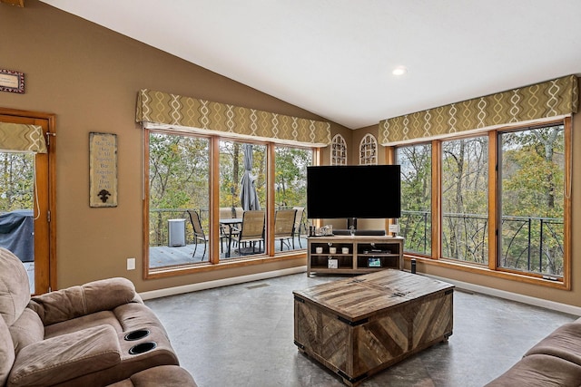 living area featuring vaulted ceiling, plenty of natural light, and baseboards