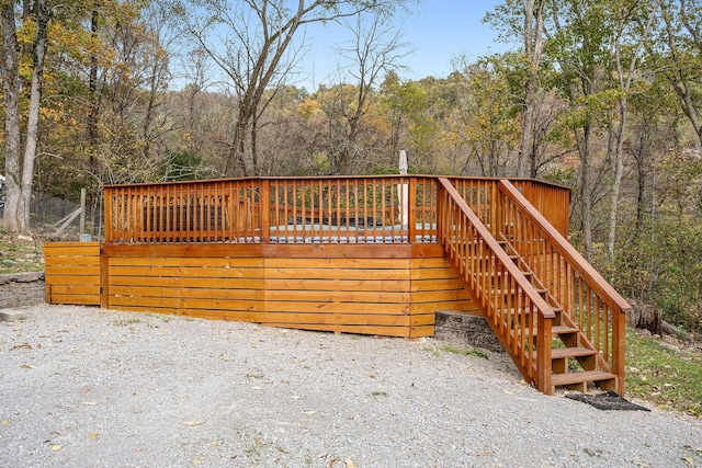 wooden terrace with stairway and a view of trees