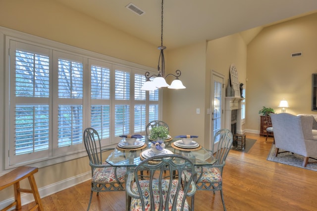 dining room with light hardwood / wood-style floors and a chandelier