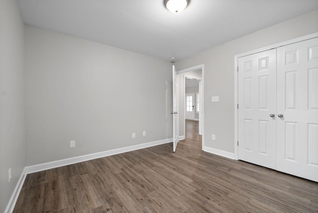 unfurnished bedroom featuring dark hardwood / wood-style floors and a closet