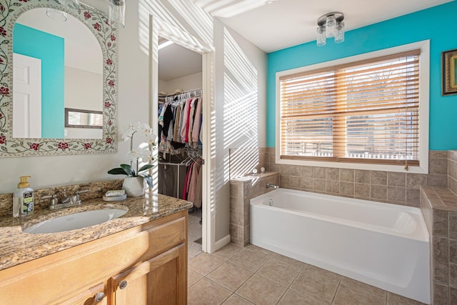 bathroom featuring tile patterned flooring, vanity, and a washtub