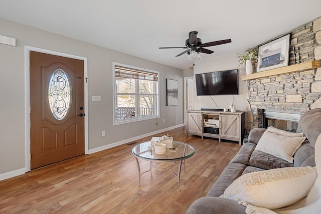 living room with hardwood / wood-style flooring, ceiling fan, and a fireplace