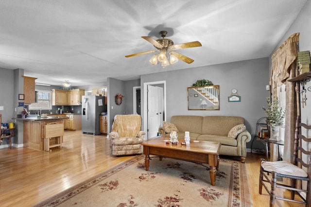 living room with light wood-type flooring and ceiling fan