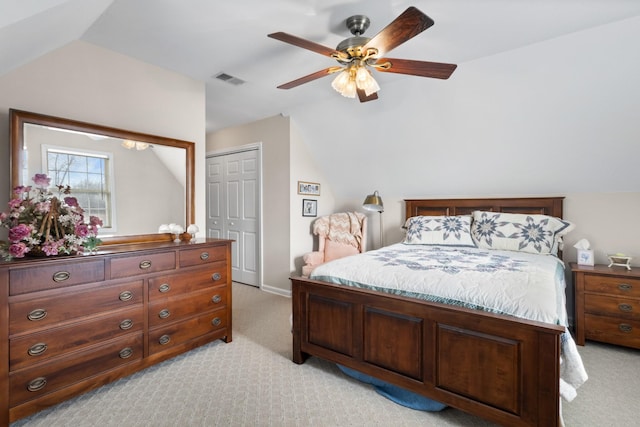 bedroom with light colored carpet, a closet, lofted ceiling, and ceiling fan