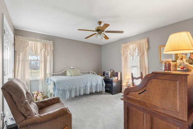 carpeted bedroom featuring ceiling fan and multiple windows