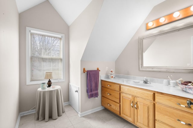 bathroom with tile patterned floors, vanity, and lofted ceiling