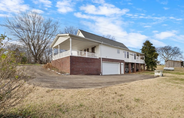 view of property exterior featuring a porch, a yard, and a garage