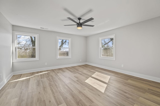 spare room featuring light wood-style flooring, baseboards, and visible vents