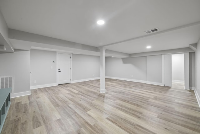 finished below grade area with recessed lighting, baseboards, visible vents, and light wood finished floors