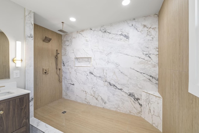 full bathroom with recessed lighting, vanity, and a tile shower