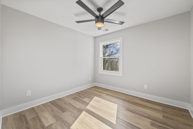 unfurnished room with ceiling fan, visible vents, baseboards, and wood finished floors