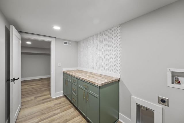 laundry area with visible vents, cabinet space, electric dryer hookup, washer hookup, and light wood-type flooring