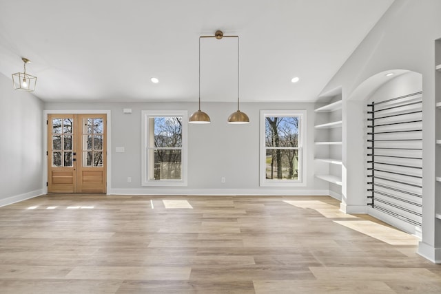 unfurnished dining area with built in features, baseboards, light wood-style flooring, recessed lighting, and stairs