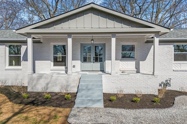 view of front of house featuring brick siding, board and batten siding, and covered porch