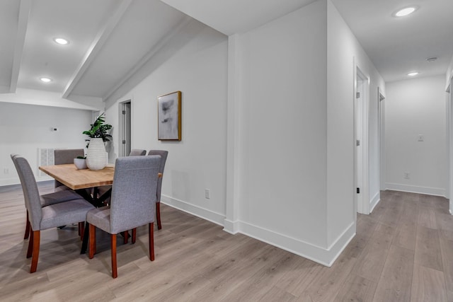 dining room with lofted ceiling and light wood-type flooring