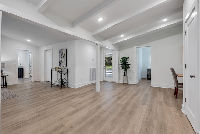 unfurnished room with vaulted ceiling with beams and light hardwood / wood-style floors