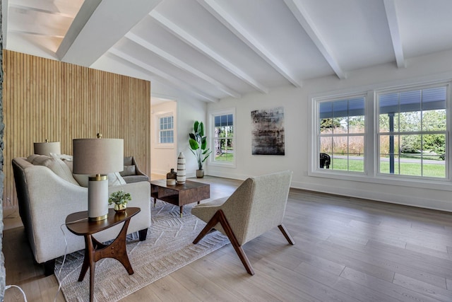 living area featuring lofted ceiling with beams and hardwood / wood-style flooring