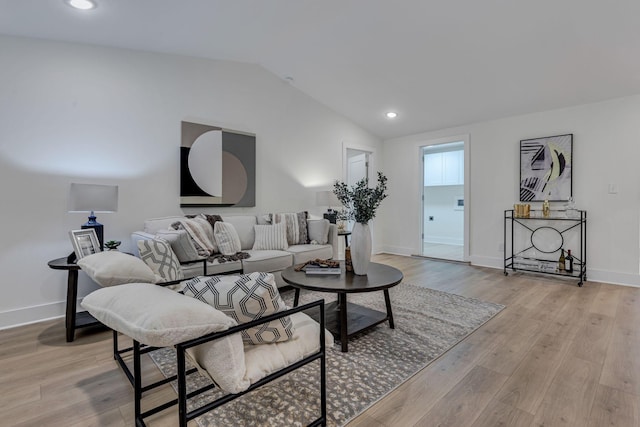 living room featuring light hardwood / wood-style flooring and vaulted ceiling