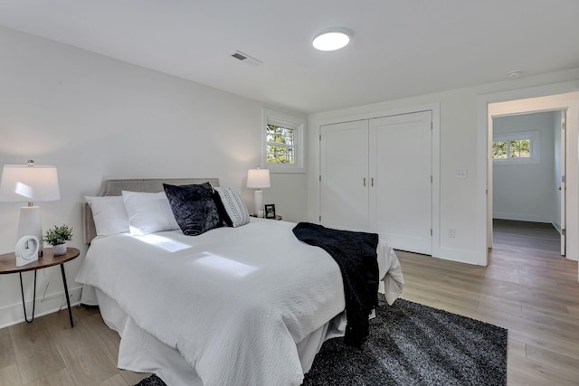 bedroom with multiple windows and light hardwood / wood-style floors