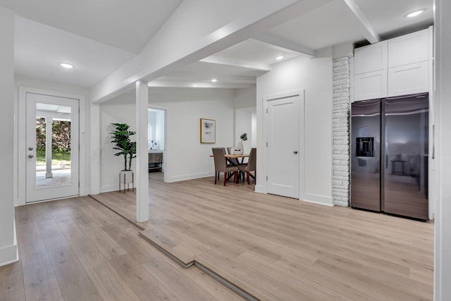 foyer with beam ceiling and light wood-type flooring