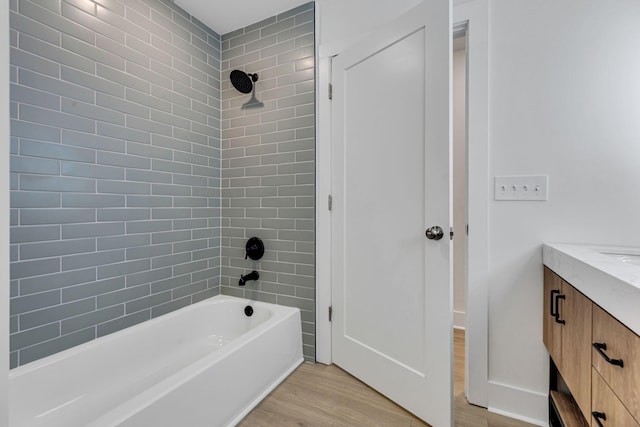 bathroom featuring hardwood / wood-style floors, vanity, and tiled shower / bath