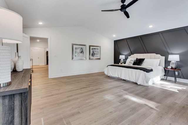 bedroom with ceiling fan, lofted ceiling, and light wood-type flooring