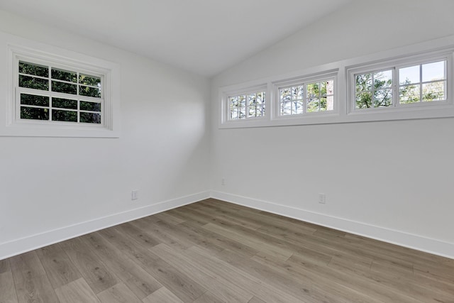 unfurnished room featuring light hardwood / wood-style flooring and vaulted ceiling