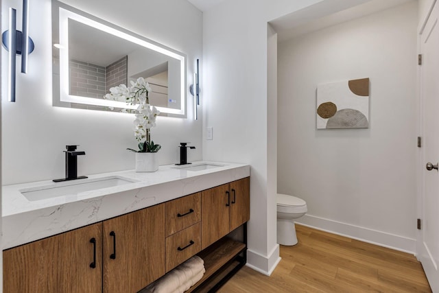 bathroom featuring toilet, vanity, and hardwood / wood-style flooring