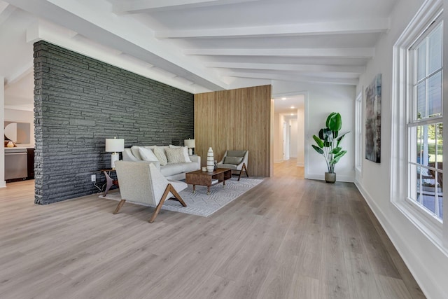 unfurnished living room featuring lofted ceiling with beams and light hardwood / wood-style flooring