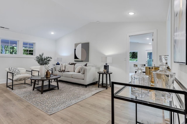 living room featuring light hardwood / wood-style flooring, a healthy amount of sunlight, and vaulted ceiling