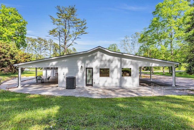 rear view of property featuring central AC unit, a yard, and a patio