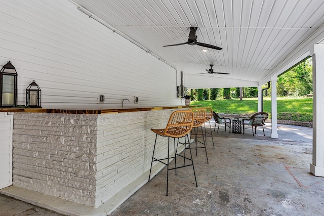 view of patio / terrace with ceiling fan and a bar