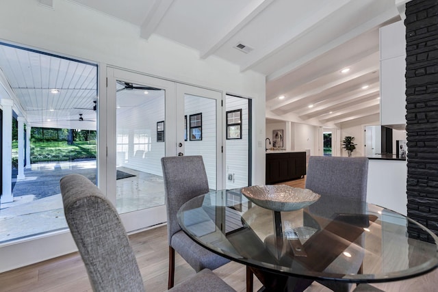 dining room featuring lofted ceiling with beams, light hardwood / wood-style floors, and ceiling fan