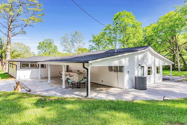 back of property featuring a patio area, a yard, and central AC