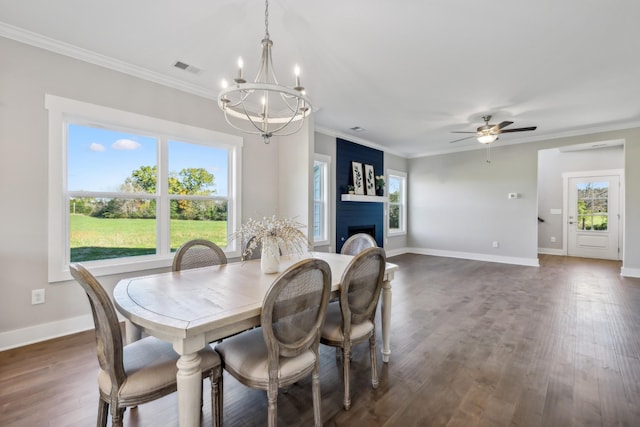 dining space with a wealth of natural light, crown molding, dark hardwood / wood-style flooring, and ceiling fan with notable chandelier