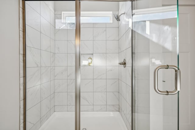 bathroom with a shower with door