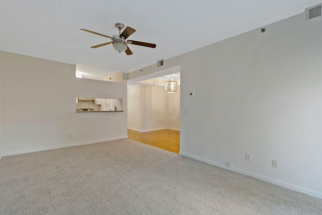 carpeted spare room with ceiling fan and ornamental molding