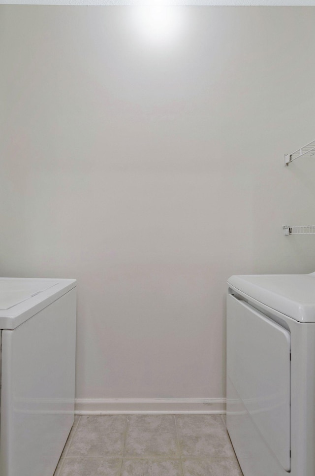 laundry area with light tile patterned floors and washing machine and clothes dryer