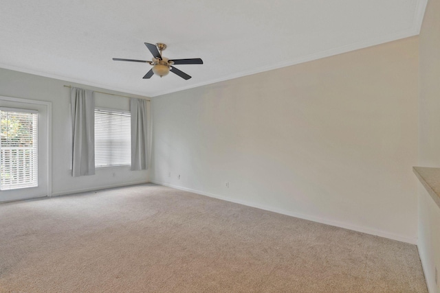 unfurnished room featuring ceiling fan, light colored carpet, and crown molding