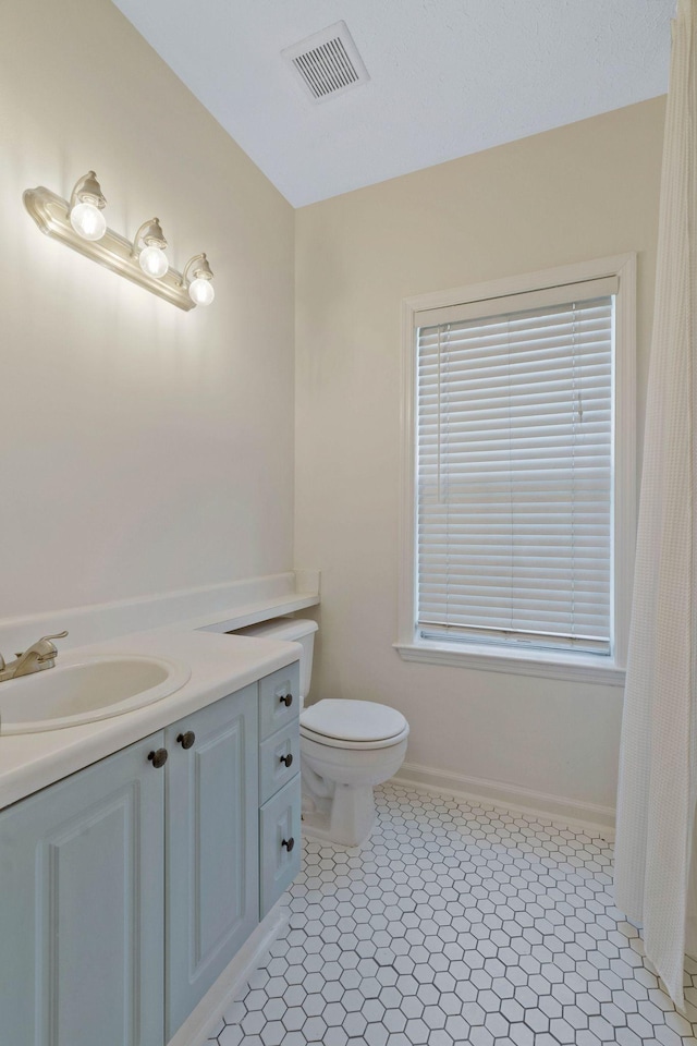 bathroom with tile patterned flooring, vanity, and toilet