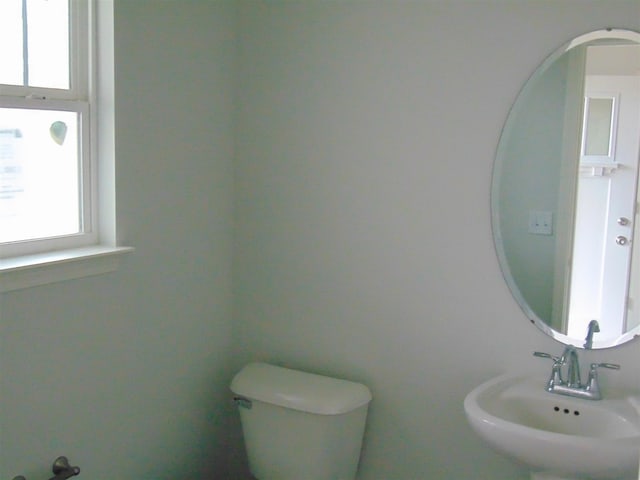 bathroom featuring toilet, plenty of natural light, and sink