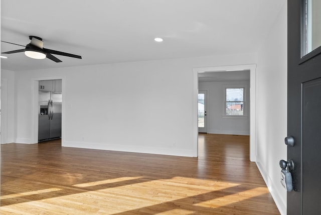 empty room with ceiling fan and dark hardwood / wood-style flooring