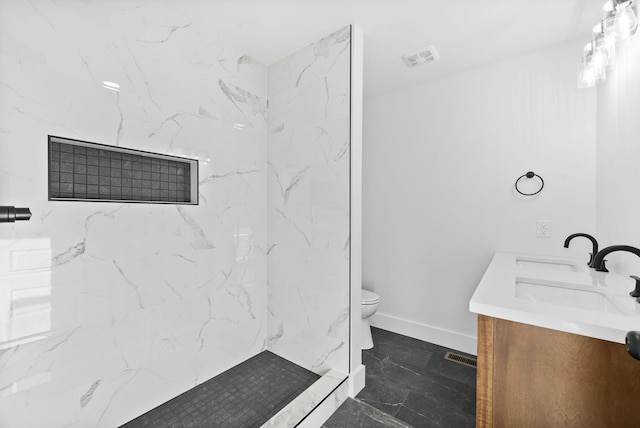 bathroom with vanity, toilet, and tiled shower