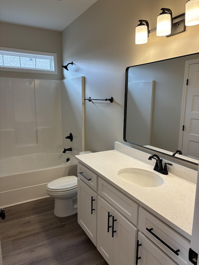 full bathroom featuring hardwood / wood-style flooring, vanity, toilet, and  shower combination