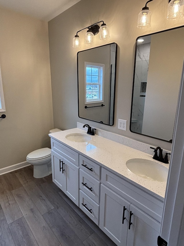 bathroom featuring hardwood / wood-style flooring, vanity, a shower, and toilet