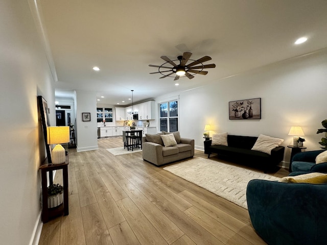 living room with ceiling fan and light wood-type flooring