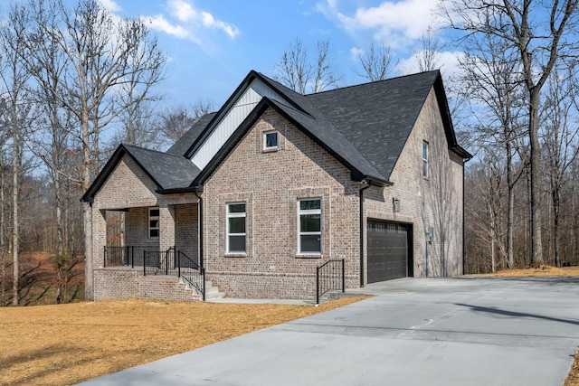 view of front of home featuring brick siding, board and batten siding, driveway, and roof with shingles