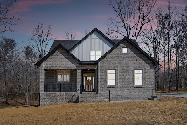 view of front of home featuring brick siding, board and batten siding, and a lawn