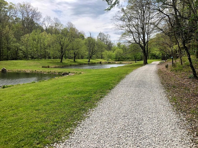 view of property's community featuring a lawn and a water view