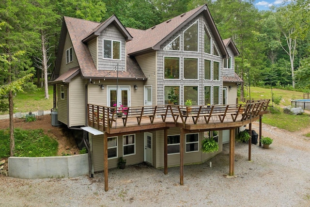 back of property with a wooden deck, central AC unit, and french doors